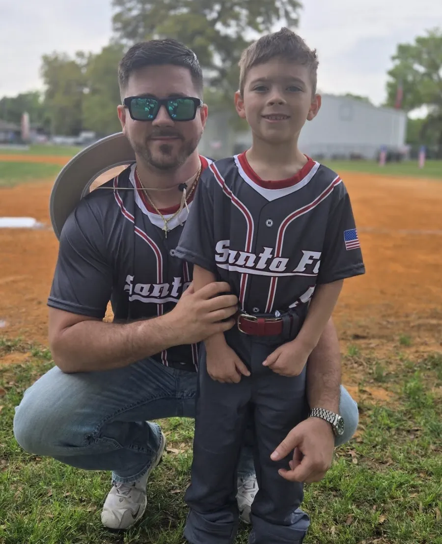 Dom DelBuco and his son in matching Santa Fe baseball jerseys on the field