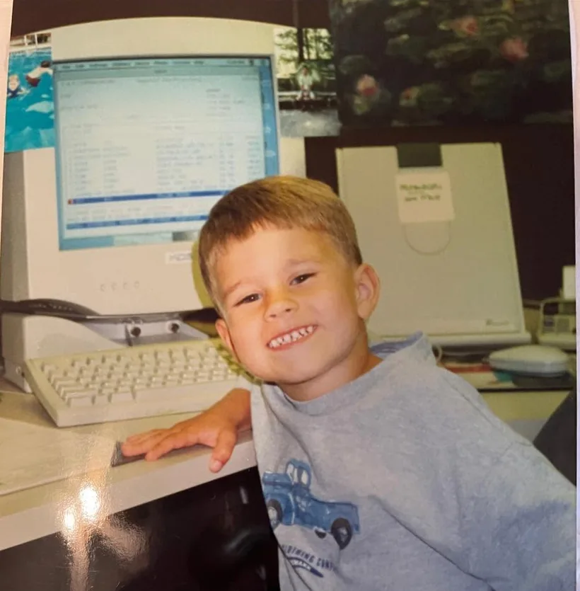 Dom DelBuco as a young boy sitting at a CRT computer